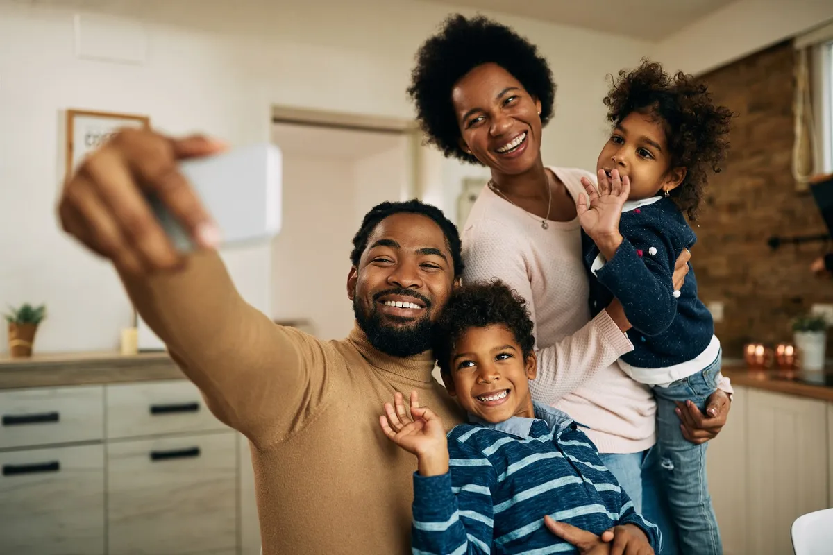 Família sorrindo em frente ao celular
